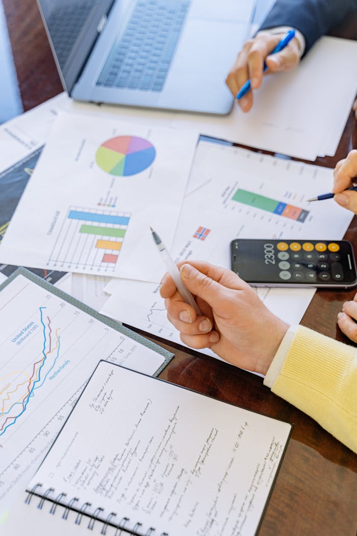 about-us A close-up of businesspeople analyzing financial data and charts during a meeting.